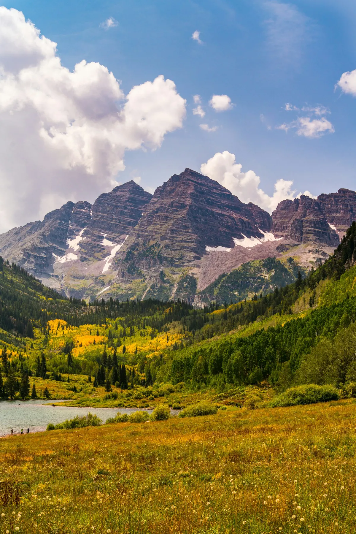 The Maroon Bells in autumn with golden meadows below