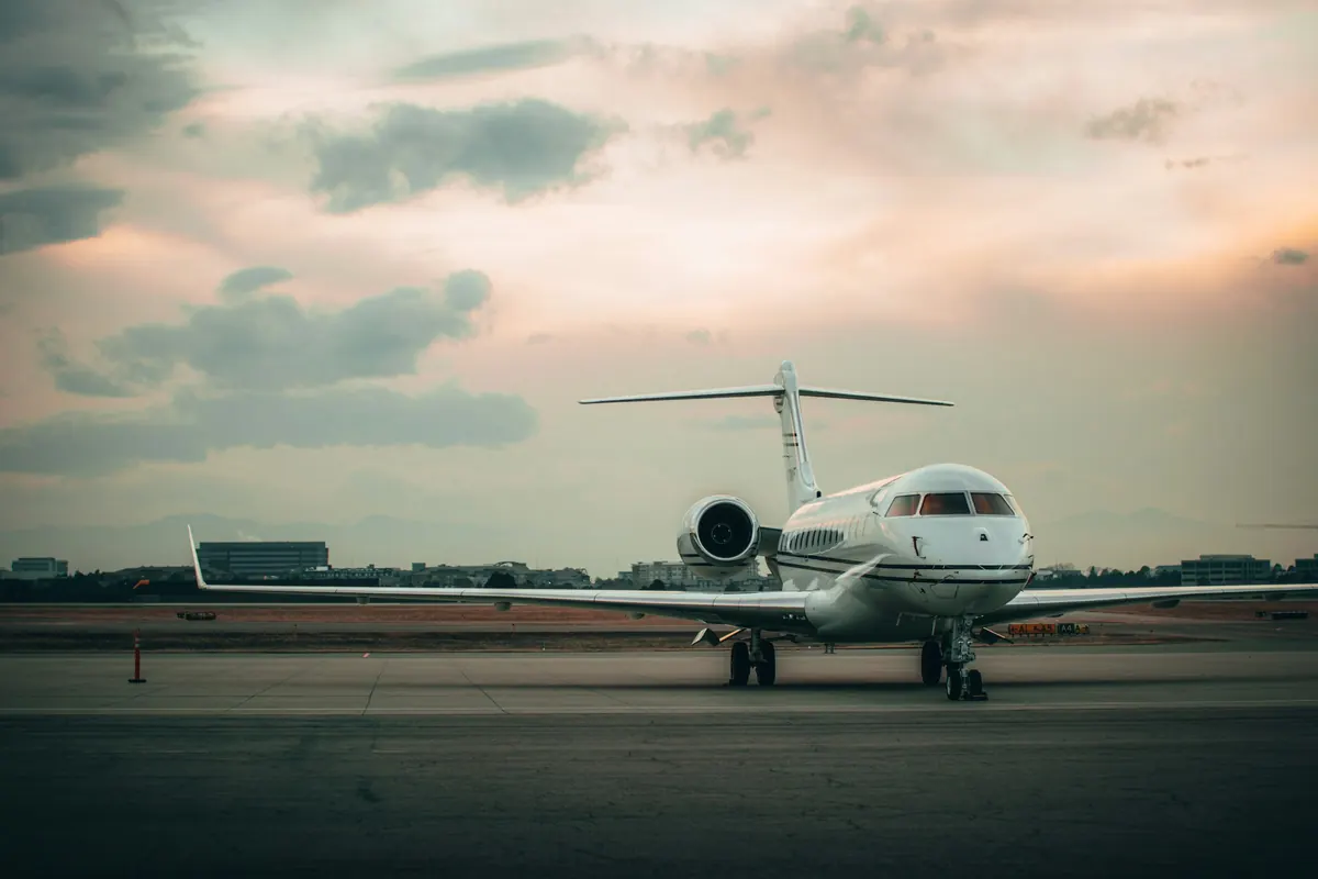 Long-range business jet facing the camera on the ramp at dusk